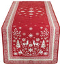 Red jacquard table runner featuring white reindeer, snowflakes, trees, and geometric borders displayed on a rectangular table.