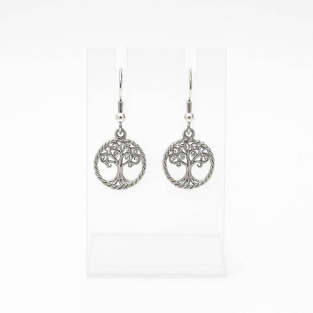 The Tree of Life Round Drop Silver Earrings feature handcrafted round silver dangle designs, shown on a clear stand with a white background.