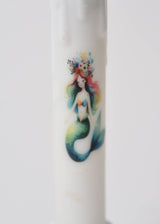 The Candle: Mermaid LED Timer Taper Candle features a vibrant mermaid with rainbow hair and a floral crown, bringing whimsical charm to any space.