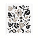 The Garden Black Gift Set includes a tea towel and dish cloth featuring black and beige floral and abstract designs on white, ideal for sustainable kitchen use.