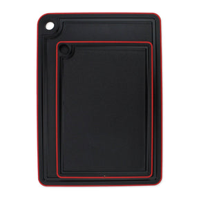 The Swedish Mimi Cutting Board Jr. set includes two black rectangular boards with a non-slip rim, red trim, juice groove around the edge, and a corner hole for hanging.