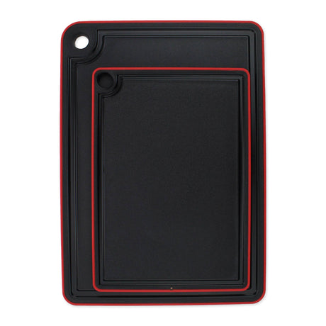 The Swedish Mimi Cutting Board Jr. set includes two black rectangular boards with a non-slip rim, red trim, juice groove around the edge, and a corner hole for hanging.