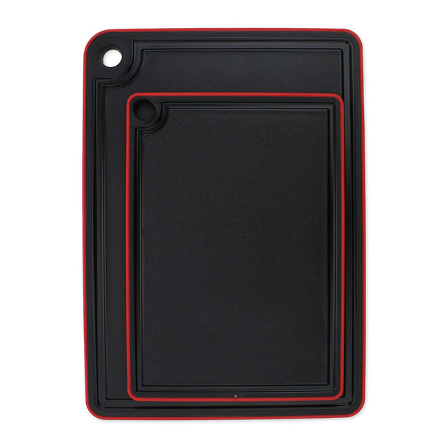 The Swedish Mimi Cutting Board Jr. set includes two black rectangular boards with a non-slip rim, red trim, juice groove around the edge, and a corner hole for hanging.