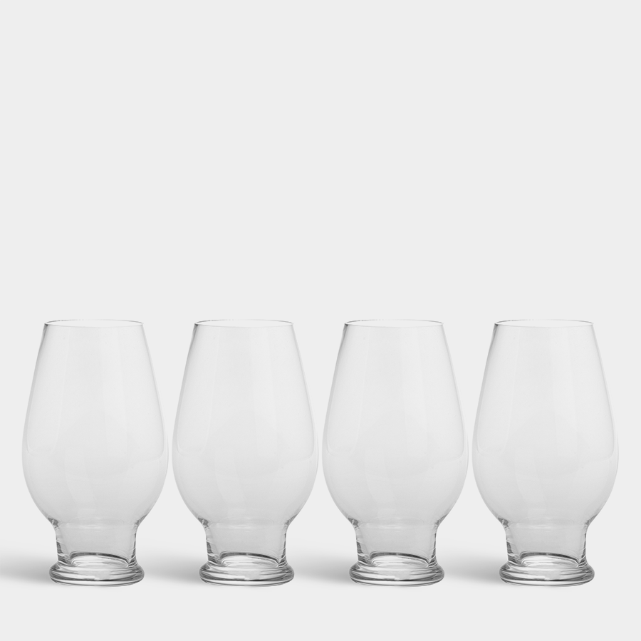 Four empty Orrefors Beer IPA 15.5oz glasses, elegantly designed by Erika Lagerbielke, are lined up on a plain white background. Their sophisticated curves make them ideal for any refined tasting experience.