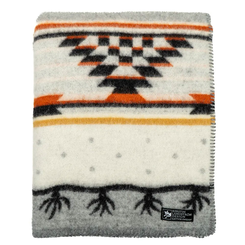 The Sundborn blanket by Kerstin Landstrom, made from 100% Norwegian lambs wool, showcases black, orange, and gray geometric patterns on cream. Its OEKO-TEX certification label ensures quality and sustainability.