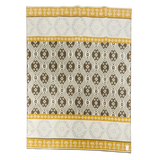 Rectangular lambswool blanket featuring yellow, brown, and white geometric and floral patterns, with yellow borders displaying white floral motifs.