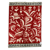 Red and cream lambswool blanket featuring Scandinavian folk art, Swedish Dala horses, stylized flowers, birds, and black-and-white geometric borders.