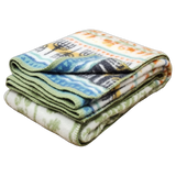 Folded fleece blanket with green trim and colorful Swedish patterns on a white background.