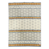 Rectangular Sámi-inspired wool blanket with gray, white, yellow, and red stripes; horizontal rows of snowflake and reindeer motifs.