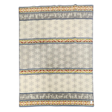 Wool blanket with Sámi-inspired rows of reindeer, snowflakes, and geometric patterns in gray, white, yellow, and red.