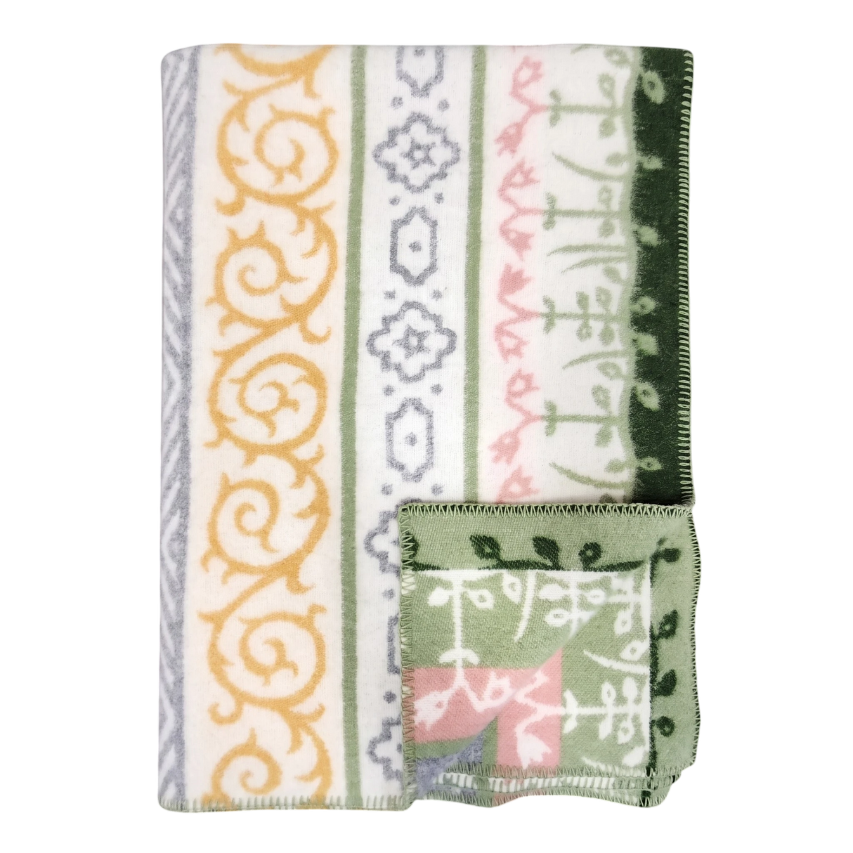 A folded blanket with green, yellow, gray, and pink geometric and floral patterns, plus a small OEKO-TEX certified square displaying matching designs on the edge.