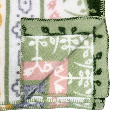 Fleece blanket with green, white, pink, and yellow patterns, folded to display both patterned sides and decorative edge stitching.