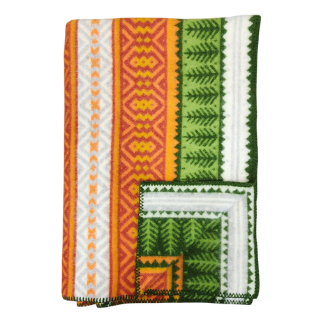 Folded blanket with orange, yellow, green, and white geometric patterns, zigzag designs, and decorative stitched border in Scandinavian style.