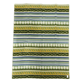 Lambswool blanket featuring green, yellow, white, and blue stripes with tree and zigzag patterns in a Swedish design.