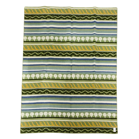 Lambswool blanket featuring green, yellow, white, and blue stripes with tree and zigzag patterns in a Swedish design.