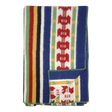 Folded Rättvik wool blanket featuring colorful vertical stripes and geometric patterns; one corner is turned up to show the reverse side.