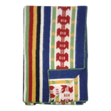 Folded Rättvik wool blanket featuring colorful vertical stripes and geometric patterns; one corner is turned up to show the reverse side.