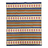 Scandinavian Rättvik wool blanket with horizontal yellow, green, black, and blue stripes and red geometric bands on a white background.