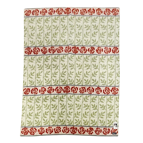 Swedish-style blanket with green leafy vine patterns and three horizontal rows of red roses on a white background.