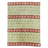 Green blanket with a white leaf pattern and three horizontal red bands, each featuring a row of white roses. Swedish design elements are visible.