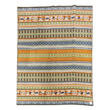 Rectangular wool blanket with horizontal green, brown, orange, and blue stripes, featuring geometric and floral patterns. Fabric is slightly wrinkled.