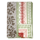 Folded lambswool blanket featuring gray, green, red, and white floral and geometric patterns on a light surface.