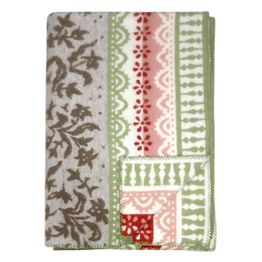Folded lambswool blanket featuring gray, green, red, and white floral and geometric patterns on a light surface.