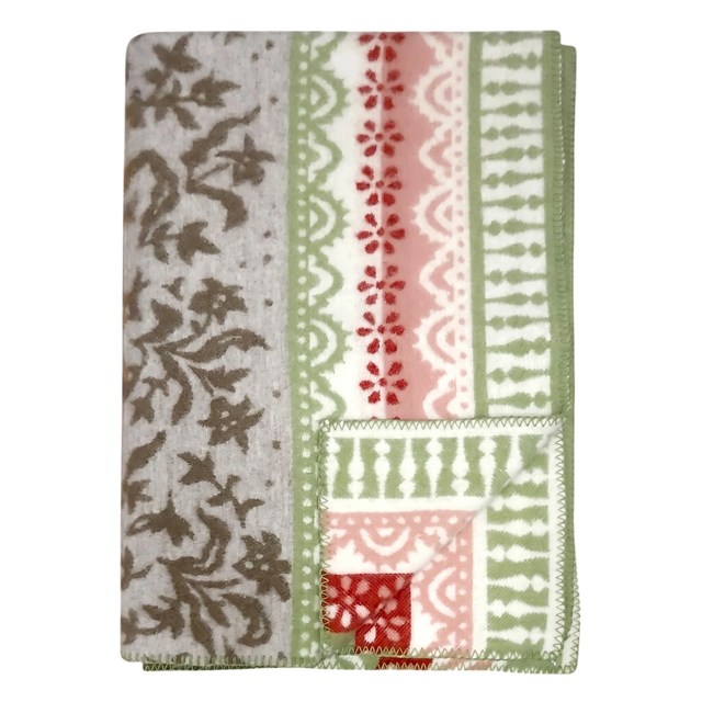 Folded lambswool blanket featuring gray, green, red, and white floral and geometric patterns on a light surface.