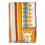 A folded Swedish blanket with yellow, orange, white, and gray stripes and geometric patterns; one corner is turned up to show the reverse side.