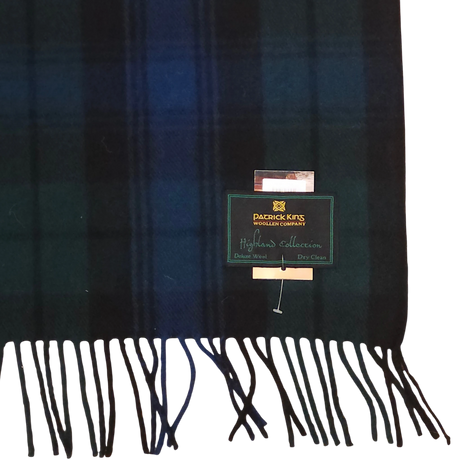 Wool scarf with dark green and navy Black Watch tartan, fringed ends, and a visible Patrick King Woollen Company Highland Collection label.