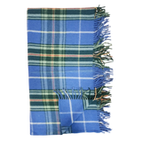 Folded Highland tartan blanket with green, white, and yellow stripes and fringed edges on a white background.