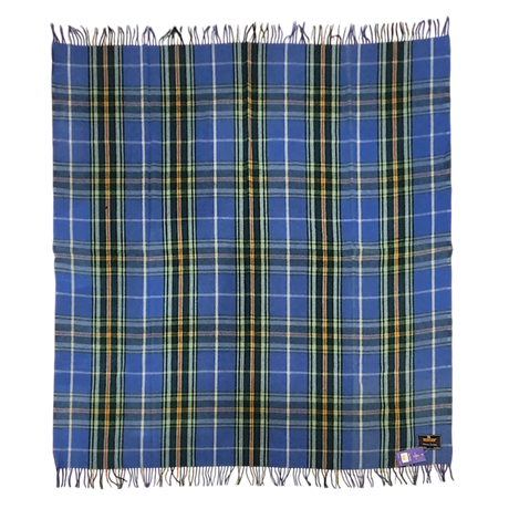 Blue Highland tartan blanket featuring yellow, white, and green stripes, fringed edges, and a label on one corner, laid flat on a white background.