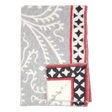Folded gray fleece blanket with white leaf patterns and a red border featuring black diamond shapes, displayed on a plain white background.