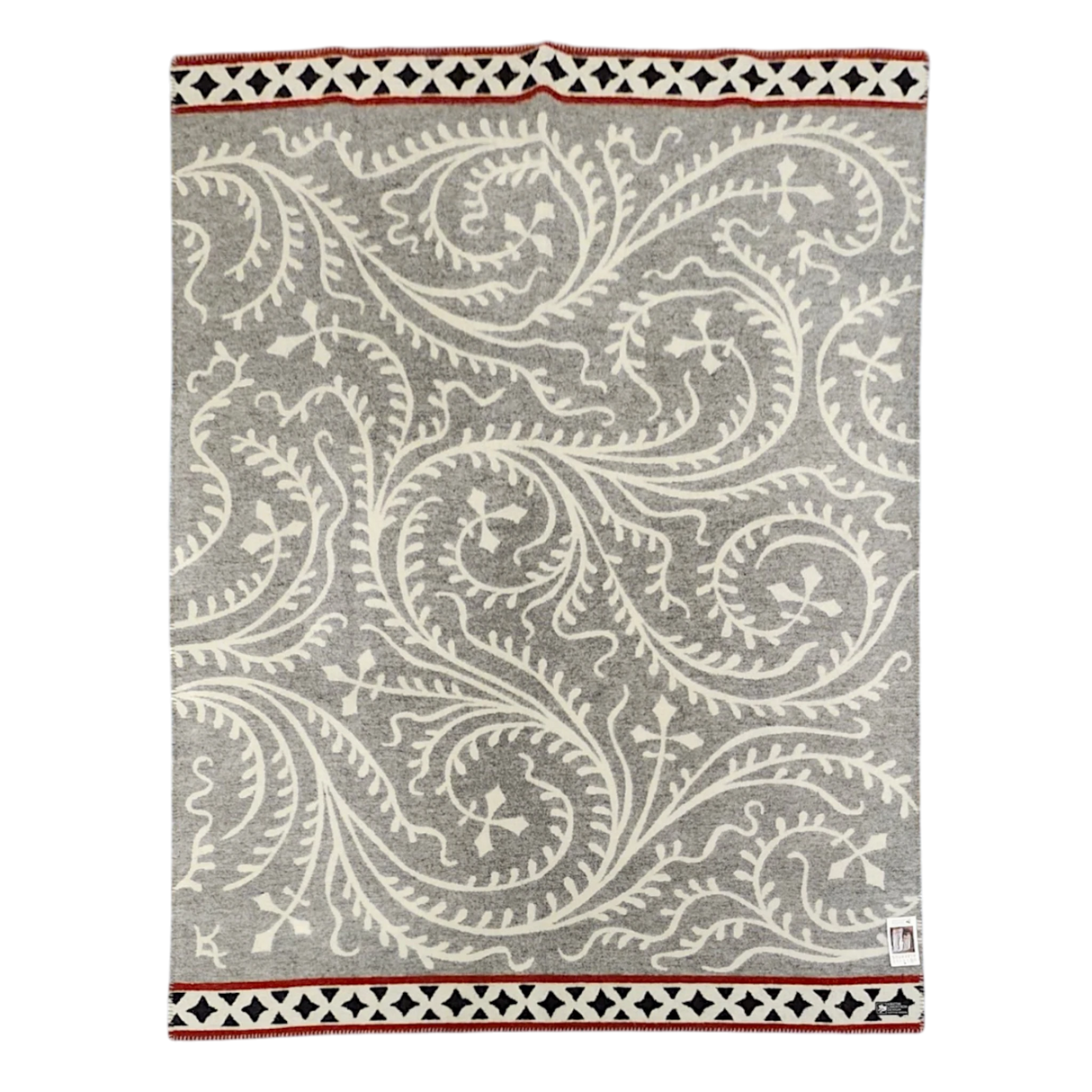 Gray and white wool blanket featuring swirling vine patterns, finished with a geometric border in black, white, and red.