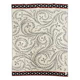Cream wool blanket with gray swirling vine patterns and black and red geometric borders.