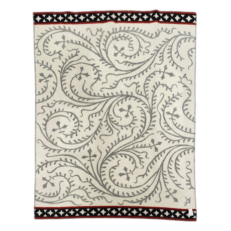 Cream wool blanket with gray swirling vine patterns and black and red geometric borders.
