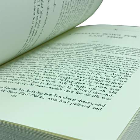 An open book with cream pages and black text, shown at an angle. The visible page references Swedish immigrants, knitting needles, and sheep shears.