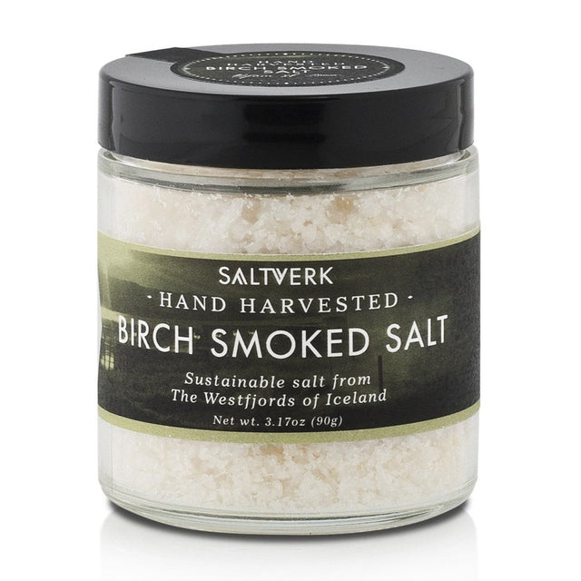 A clear jar labeled Saltverk - Birch Smoked Salt (90g, 3.17oz), containing coarse hand-harvested sustainable salt from the Westfjords of Iceland, highlighting its Icelandic tradition.
