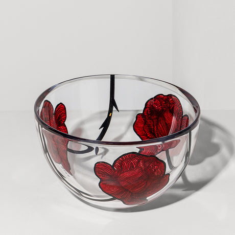 The KostaBoda Tattoo Bowl Large by Ludvig Lofgren features hand-painted red rose and black stem designs on inner and outer clear glass, shown here on a white surface.