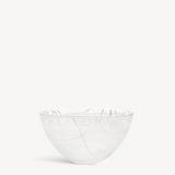 A KostaBoda Contrast Bowl by Anna Ehrner, featuring white glass with blue and black veining, shown against a plain white background.
