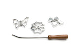 The Cookie Cutter: Rosette Set, Cast-Aluminum, 4-Piece Set includes three metal rosette irons—butterfly, flower, and heart shapes—and a wooden-handled wand, ideal for baking Scandinavian rosette cookies. All shown on a white background.