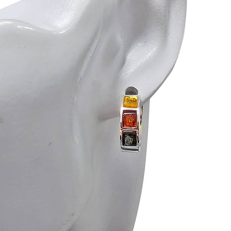 Multicolor 3 amber stones (yellow, red, gray) set in .925 sterling silver hoop earrings elegantly displayed on a white mannequin ear.