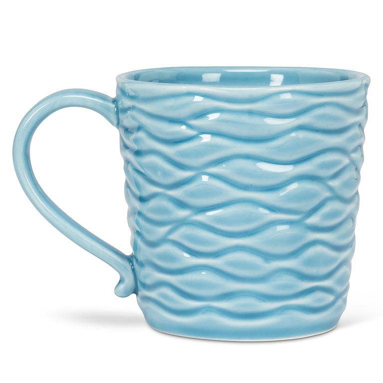 The Wavy Aqua Mug with Loon in Recess is a handcrafted ceramic mug (14oz, 4"H) featuring a light blue wavy texture and curved handle—a nature-inspired gift shown on a white background.