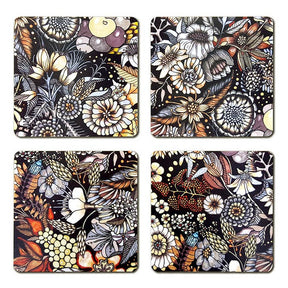 The Flores-Flowers Coaster set by Swedish artist Nadja Wedin includes 4 laminated birchwood coasters, each with a unique floral design in black, white, yellow, and orange on a dark background.