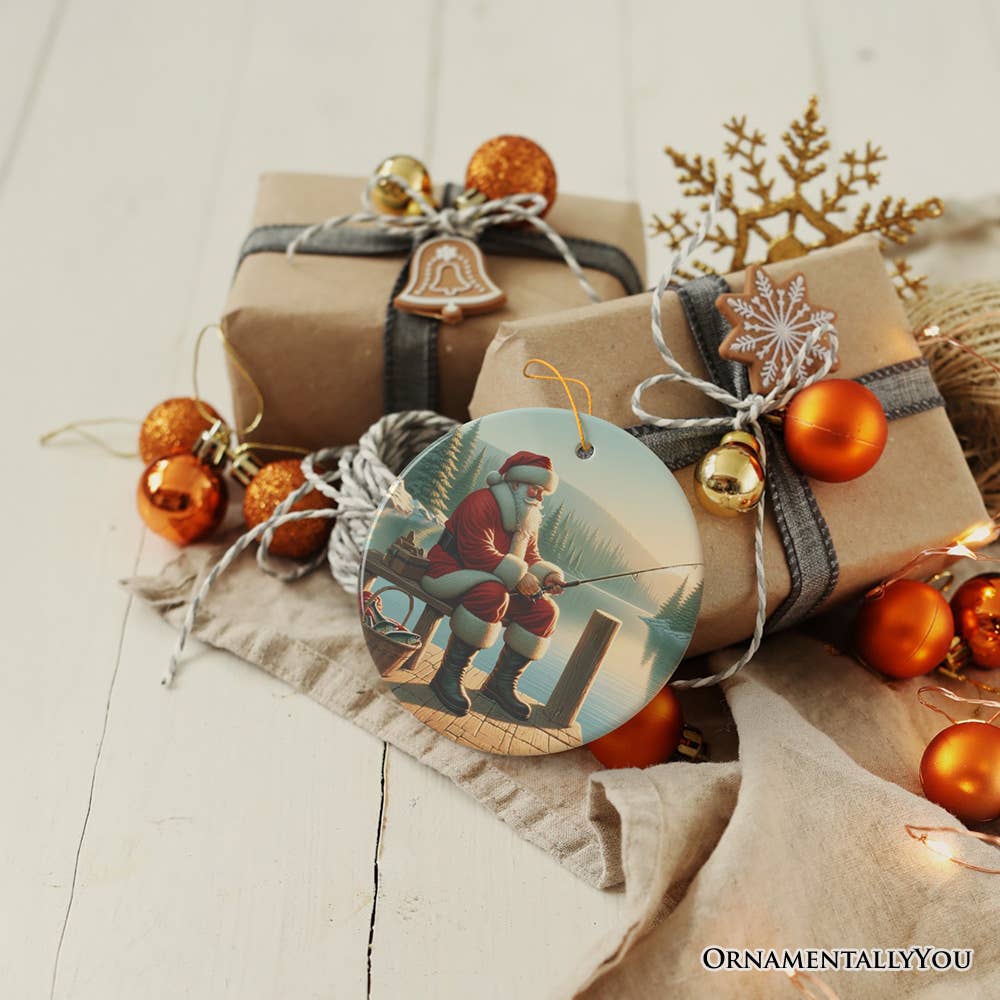 Christmas presents wrapped in brown paper and gray ribbon, adorned with orange baubles and the "Peaceful Fishing Session with Santa Claus" ornament tag, are arranged on a light wooden surface—a perfect Christmas gift for anglers.