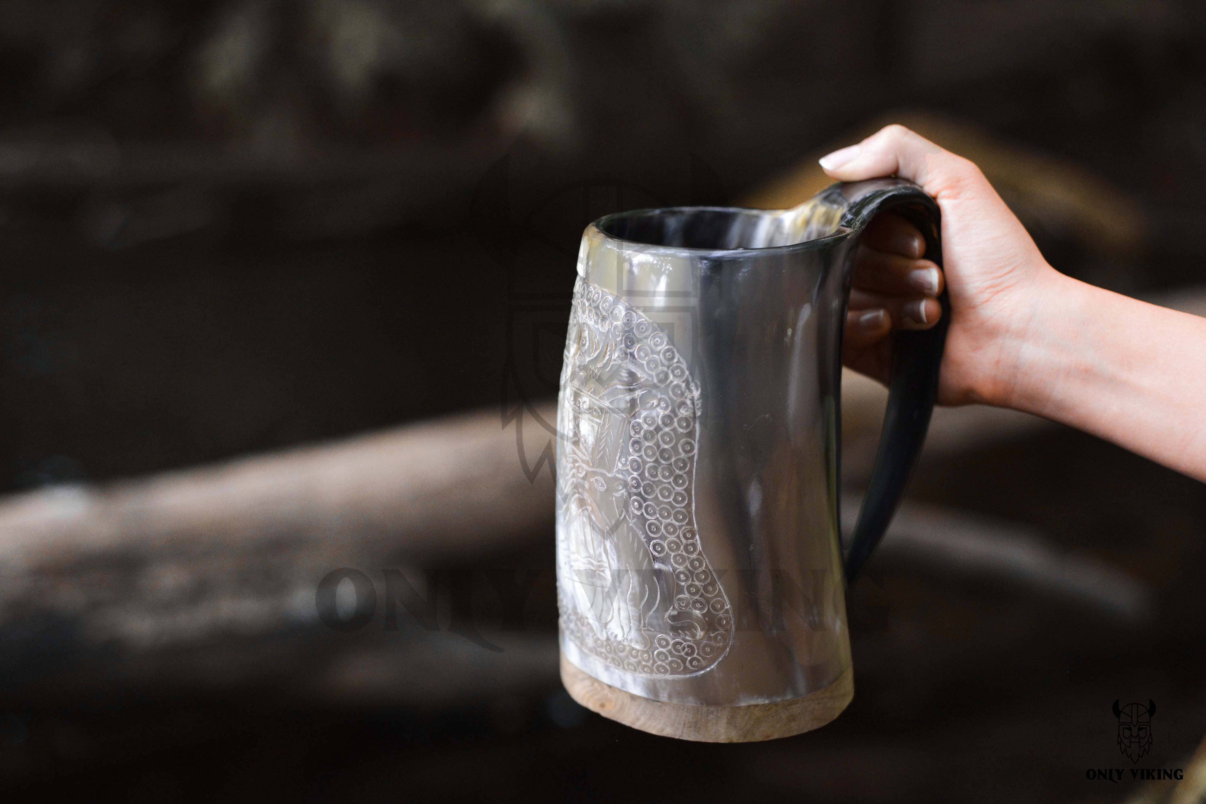 A hand holding the Horn: Viking Tankard, a large white mug with black accents, featuring an intricate design inspired by ancient Viking ships.