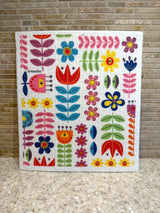 Square Swedish dishcloth featuring a colorful folk-art pattern of stylized flowers and leaves.