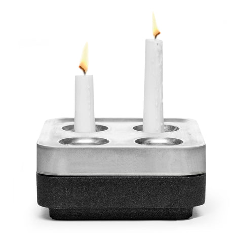 The Stumpastaken Fyran Four Candle Holder - Square, made from 100% recycled material with a white powder-coated finish, holds candles of varying heights for a stylish, sustainable interior decor accent.