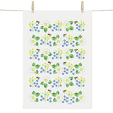 The Swedish Summer Flowers Tea Towel by Anneko Design Sweden hangs on a line, adorned with daisies, yellow and blue blooms, green leaves, and small bees in a vibrant floral pattern.