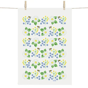 The Swedish Summer Flowers Tea Towel by Anneko Design Sweden hangs on a line, adorned with daisies, yellow and blue blooms, green leaves, and small bees in a vibrant floral pattern.
